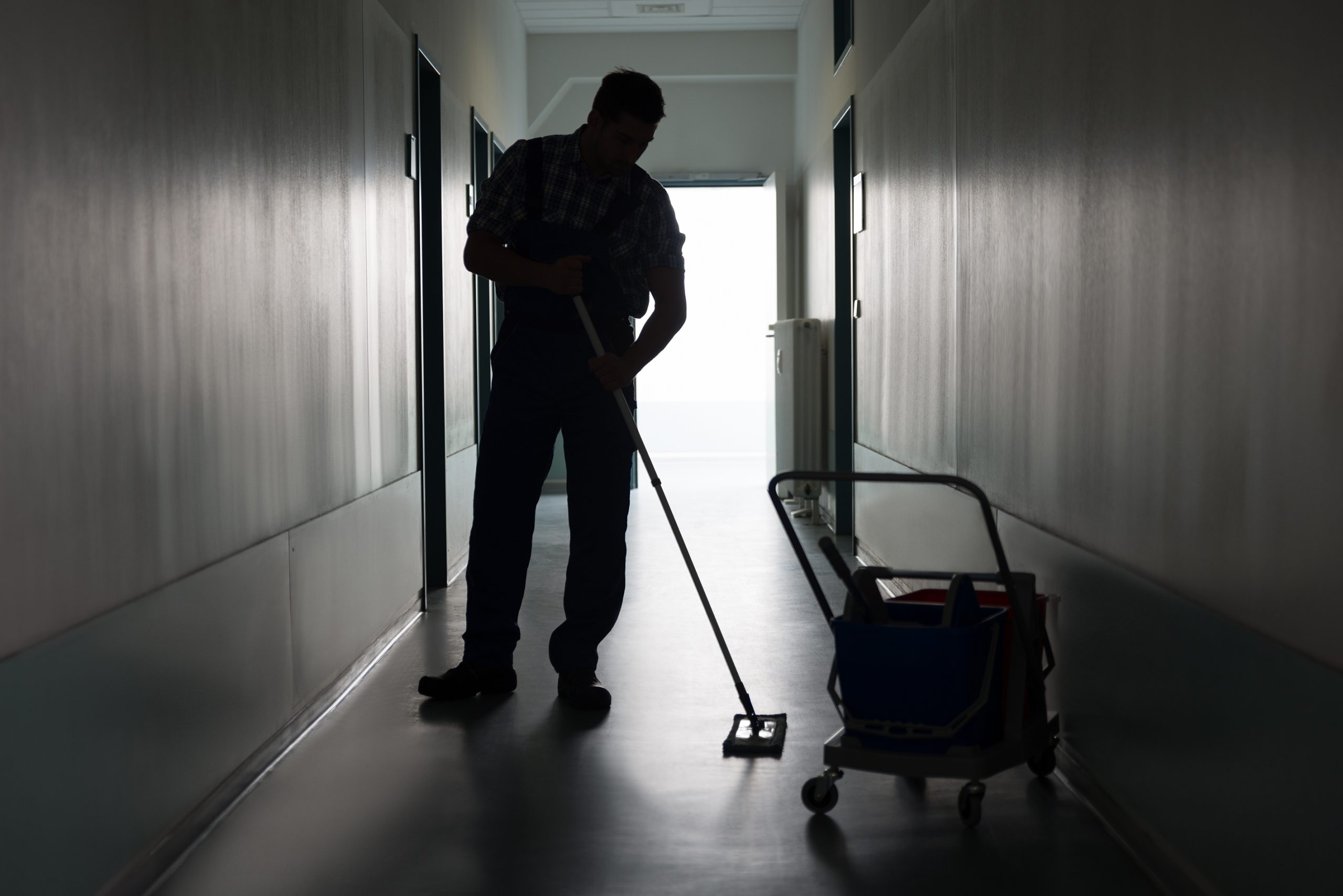 Full length of silhouette man with broom cleaning office corridor; Shutterstock ID 235315258; other: -; purchase_order: -; client: -; job: -
